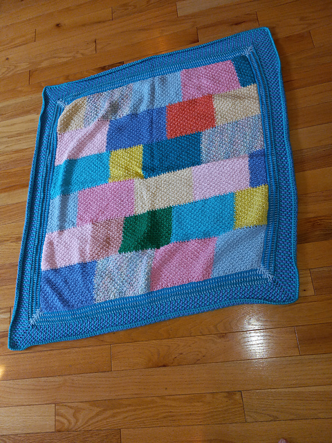 Blanket of pastel Tunisian honeycomb blocks with a blue border