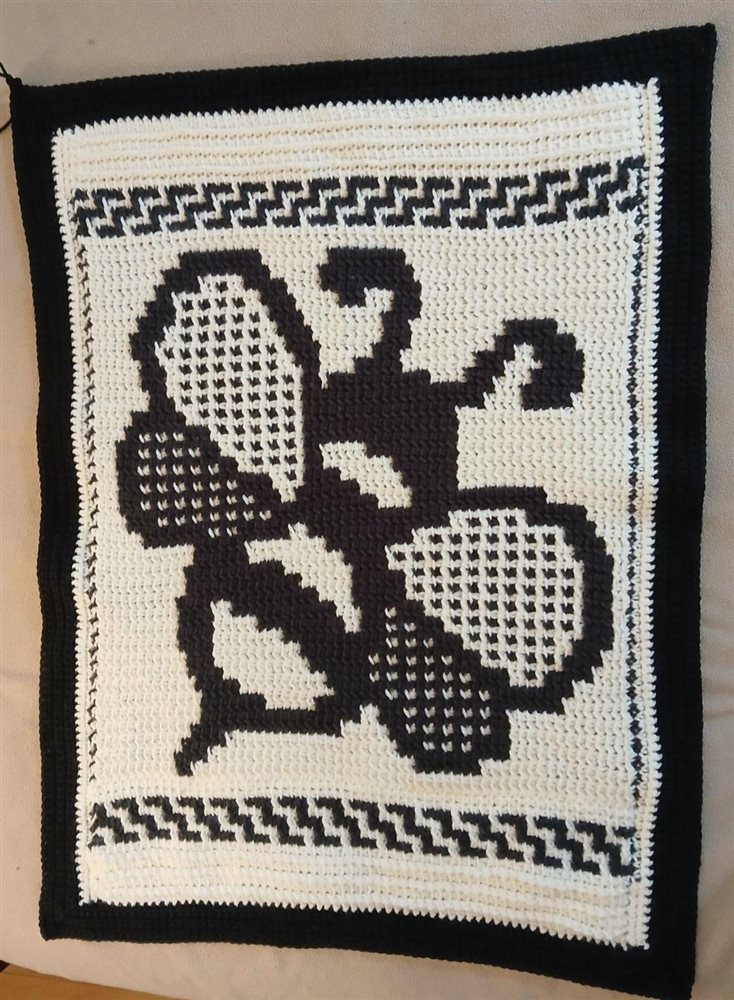 Finished black and white crocheted panel with a large mosaic bee and border bands